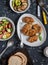 Quinoa crusted chicken, vegetable salad, grilled eggplant and pepper - dinner table. On a dark background