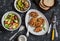 Quinoa crusted chicken, vegetable salad, grilled eggplant and pepper - dinner table. On a dark background