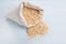 Quinoa flakes in a cream fabric bag on blue wooden board