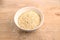 Quinoa flakes in a mixing bowl on a wooden board