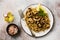 Quinoa, fried mushrooms and lemon for wholesome meal served in simple ceramic plate.