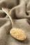 Quinoa grain in metal spoon on sackcloth background