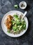 Quinoa, roasted chicken breast, avocado, cheese, cilantro bowl on dark background, top view. Healthy eating concept