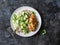 Quinoa, roasted chicken breast, avocado, cheese, cilantro bowl on dark background, top view. Healthy eating concept