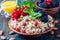 Quinoa salad with berries, mint and walnuts on a dark wooden background. Superfoods clean eating concept.