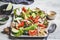 Quinoa salad with tomato, cucumber, radish and avocado on gray plate. Healthy vegan food concept