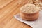 Quinoa in wooden bowl on brown bamboo board, close up. Rustic style, healthy dietary groats background.