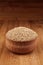 Quinoa in wooden bowl on brown bamboo board, close up. Rustic style, healthy dietary groats background.