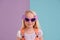 Quirky and colorful...and thats just her personality. A cute little girl wearing funny sunglasses against a colorful