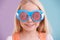 Quirky and colorful...and thats just her personality. A cute little girl wearing funny sunglasses against a colorful