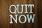 Quit Now word alphabet letters on wooden background