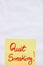 Quit smoking handwriting text close up isolated on yellow paper with copy space