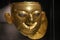 QUITO, ECUADOR - AUGUST 24, 2018: Close up of beautiful golden Inca face inside of el Agora museum located in Casa de la