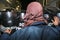 Quito, Ecuador - August 27, 2015: Man wearing denim jacket and face covered standing in front of police shields protesting