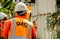 QUITO, ECUADOR - FEBRUARY 26, 2018: Close up of EPMMOP man wearing orange uniform and cleaning and picking up pieces of