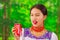 Quito, Ecuador - May 06, 2017: Beautiful young indigenous woman drinking a coke and doing a a ugly face in a forest