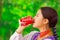 Quito, Ecuador - May 06, 2017: Beautiful young indigenous woman drinking a coke in a forest background