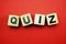 Quiz letters alphabet wooden cubes on red background