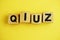 Quiz letters alphabet wooden cubes on yellow background