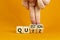 Quiz or question symbol. Businessman hand turns cubes and changes the word `quiz` to `question`. Beautiful orange background.