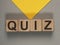 Quiz or quizz concept. Word on wood cubes on gray and yellow background