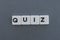 Quiz word made of square letter word on grey background