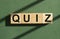 Quiz word on wooden cubes on green sunny background. Quizz game concept