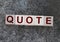 Quotes - word from wooden blocks with letters, citation official notice or quotation concept, grey background