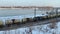 R_baikal_45 A freight train with round tank wagons travels on rails along the Angara River in Irkutsk. Winter landscape.