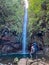 Rabacal - Father with baby carrier looking at majestic waterfall Cascata das 25 Fontes along idyllic Levada walk 25 Fontes