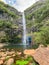 Rabacal - Father with baby carrier looking at majestic waterfall Cascata Risco along idyllic Levada walk 25 Fontes