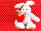 Rabbit doll with red heart on red polka dot background