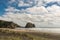 Rabbit rock and Piha Beach seen from along the beach.