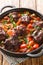 Rabo de toro or oxtail stew in cooking pot closeup on plate on the table. Vertical