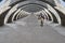 Race biker approaches under concrete arcades