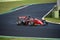 Racing car single seater modern formula in action at turn on wet asphalt track