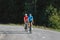 Racing cyclist couple in sports jerseys, pedaling on a road