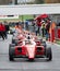 Racing formula cars front view aligned in asphalt circuit pit lane