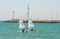 Racing sailboats near the lighthouse of the town of Pomorie, Bulgaria