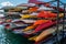 Rack of colorful kayaks and canoes.