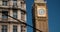 Rack focus shot of red London bus and Big Ben, Houses of Parliament in a blue sky, summer, London, England