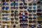 A rack full of various sunglasses for sale outside a seaside shop