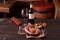 Rack of lamb on a cutting board with rosemary, olive oil, yellow and red tomatoes on a twig on a wooden background