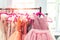 Rack with many beautiful holiday dresses for girls on hangers at children fashion showroom indoor. Kid girl dress hire studio for