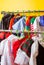 Rack with many cool holiday costumes for kids on hangers at children fashion showroom. Rental service in the cloth shop.