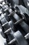 A rack of rubber coated dumbbells of various weights at the gym. Weight training equipment