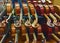 Rack of violins awaiting work in violin repair shop.