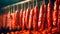 Racks of smoked spicy sausages hanging in the smokehouse. Meat production. Sausage hanging. Meat products.