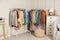 Racks with stylish clothes in cozy room interior. Fast fashion