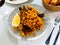 Racy seafood paella with mussels, squid rings and lemon